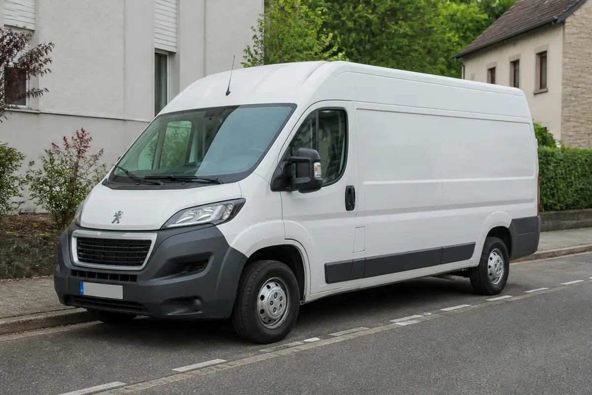 Camionnette blanche illustrant les dimensions du Peugeot Boxer L2H2 garé en ville