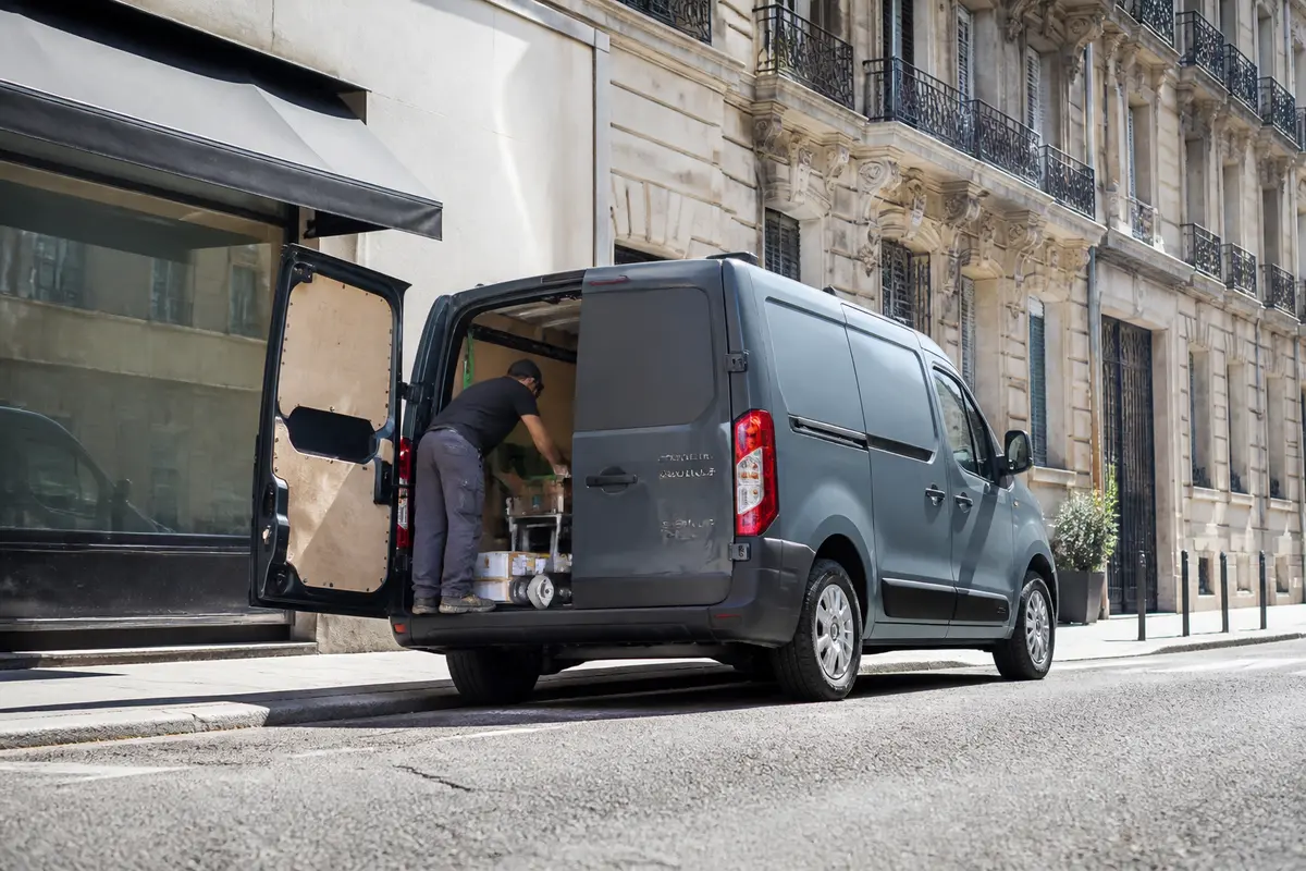 Homme charge camion avec dimensions du Renault Master L1H1 sur rue parisienne