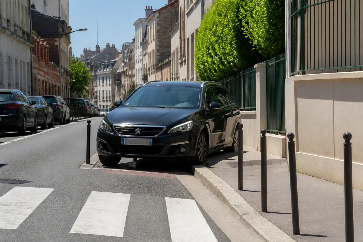 Voiture garée sur le trottoir en ville, infraction NATINF 7588 au code de la route