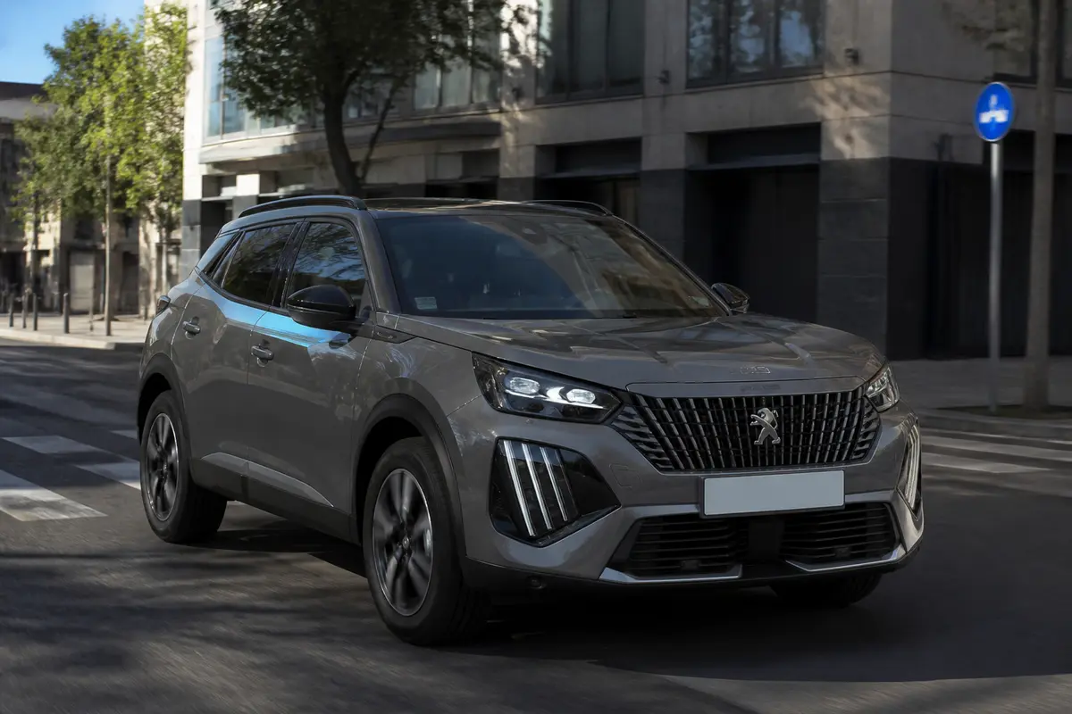 SUV Peugeot 2008 gris circulant en ville sur une route dégagée ensoleillée