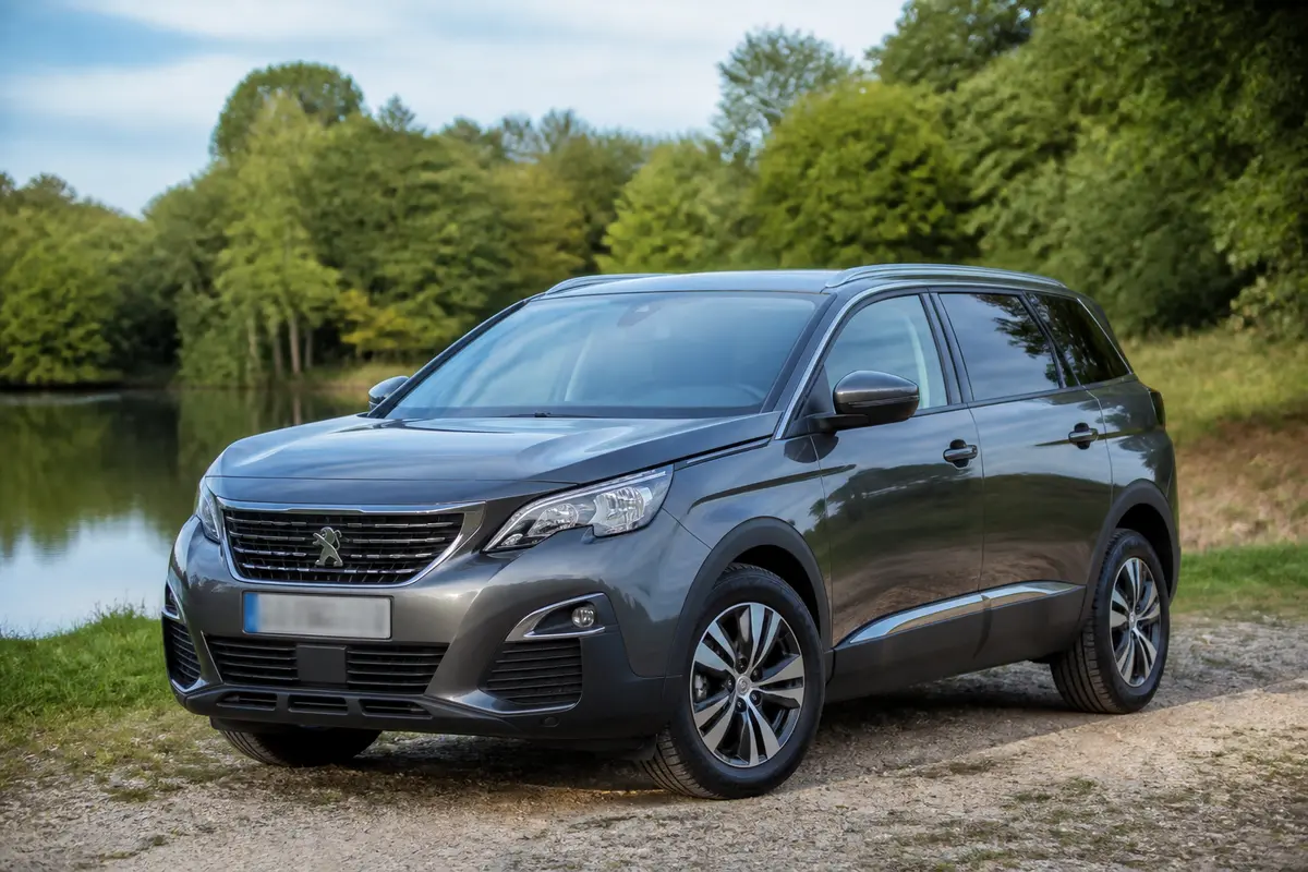 Peugeot 5008 1.5 BlueHDi 130 garé en extérieur, fiabilité reconnue en nature verdoyante