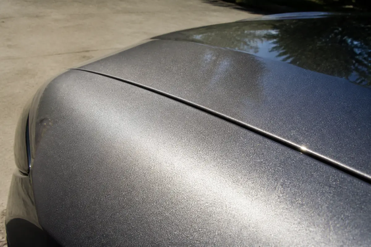 Capot de voiture avec finition en peinture métallisée reflétant la lumière douce