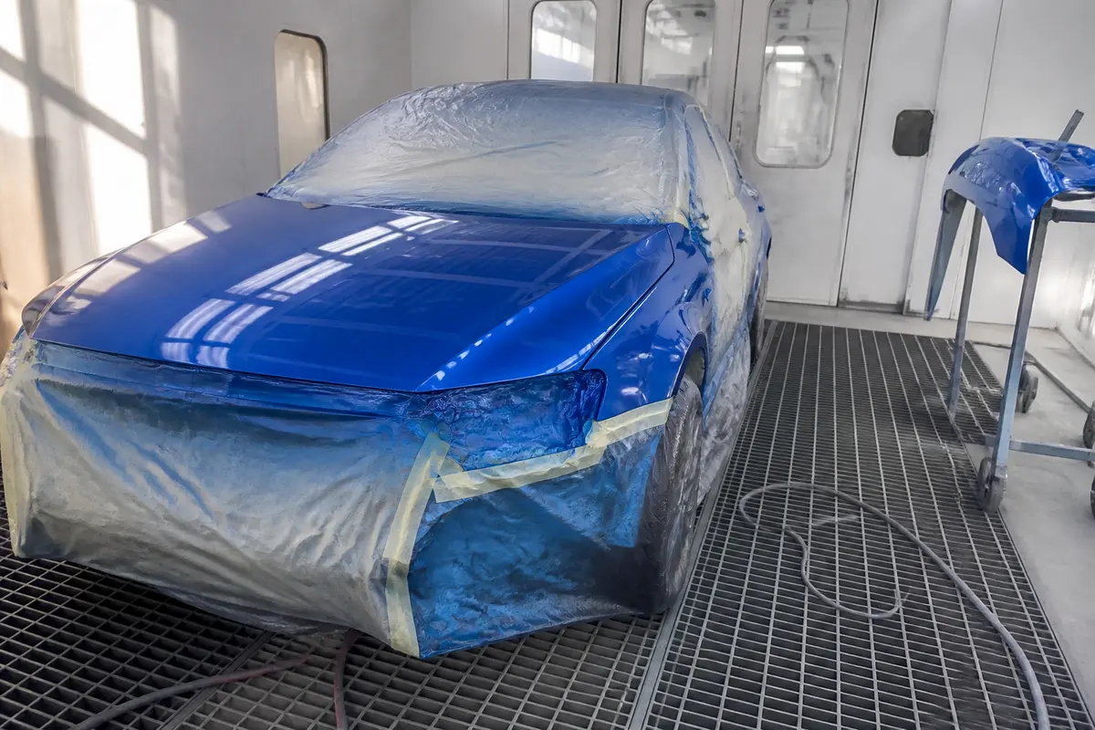 Voiture bleue en cabine de peinture, estimée pour le prix d'une peinture complète